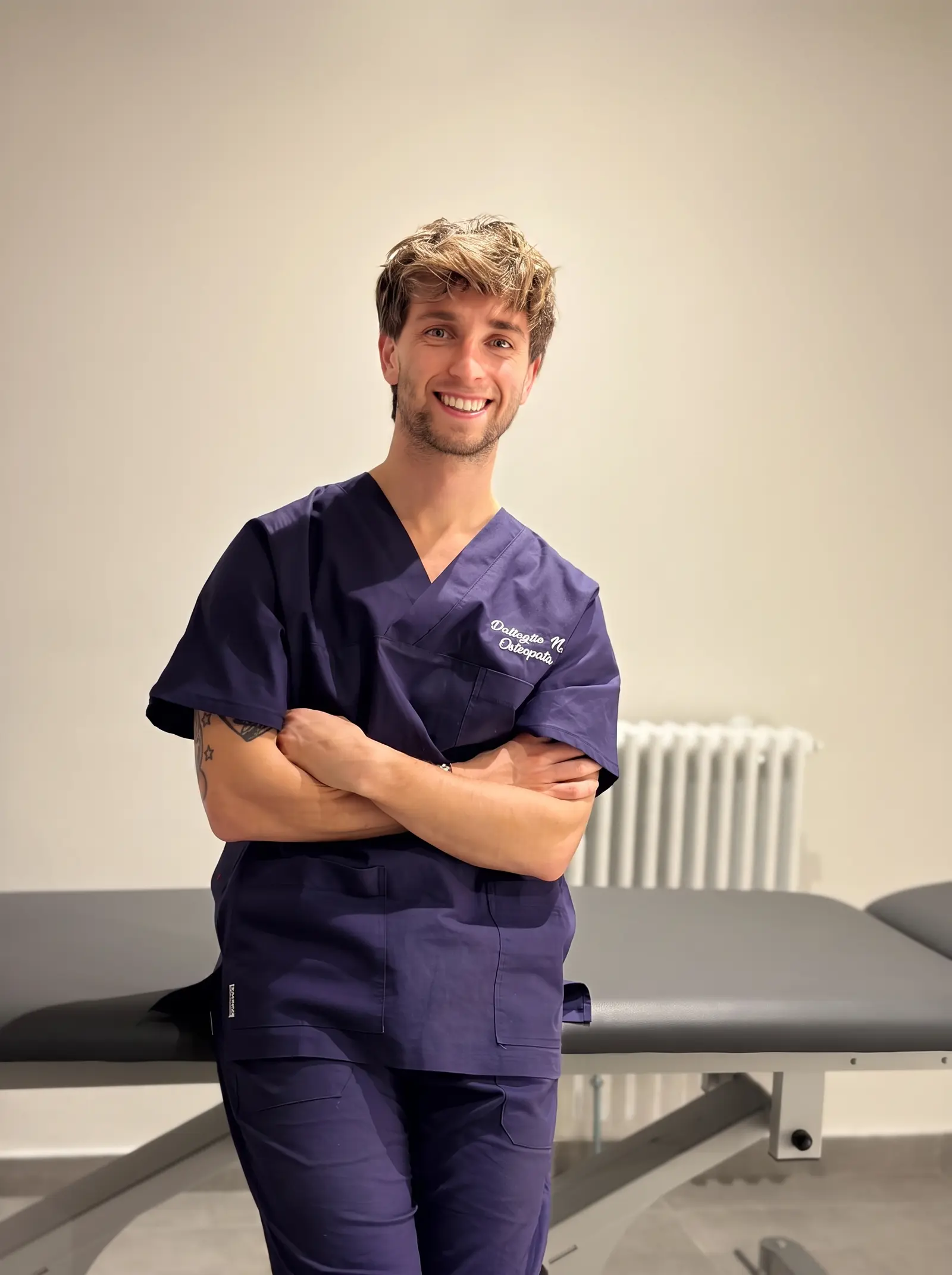 Nicolò Dallaglio, osteopata, sorride in camice nel suo studio di Montecchio Emilia